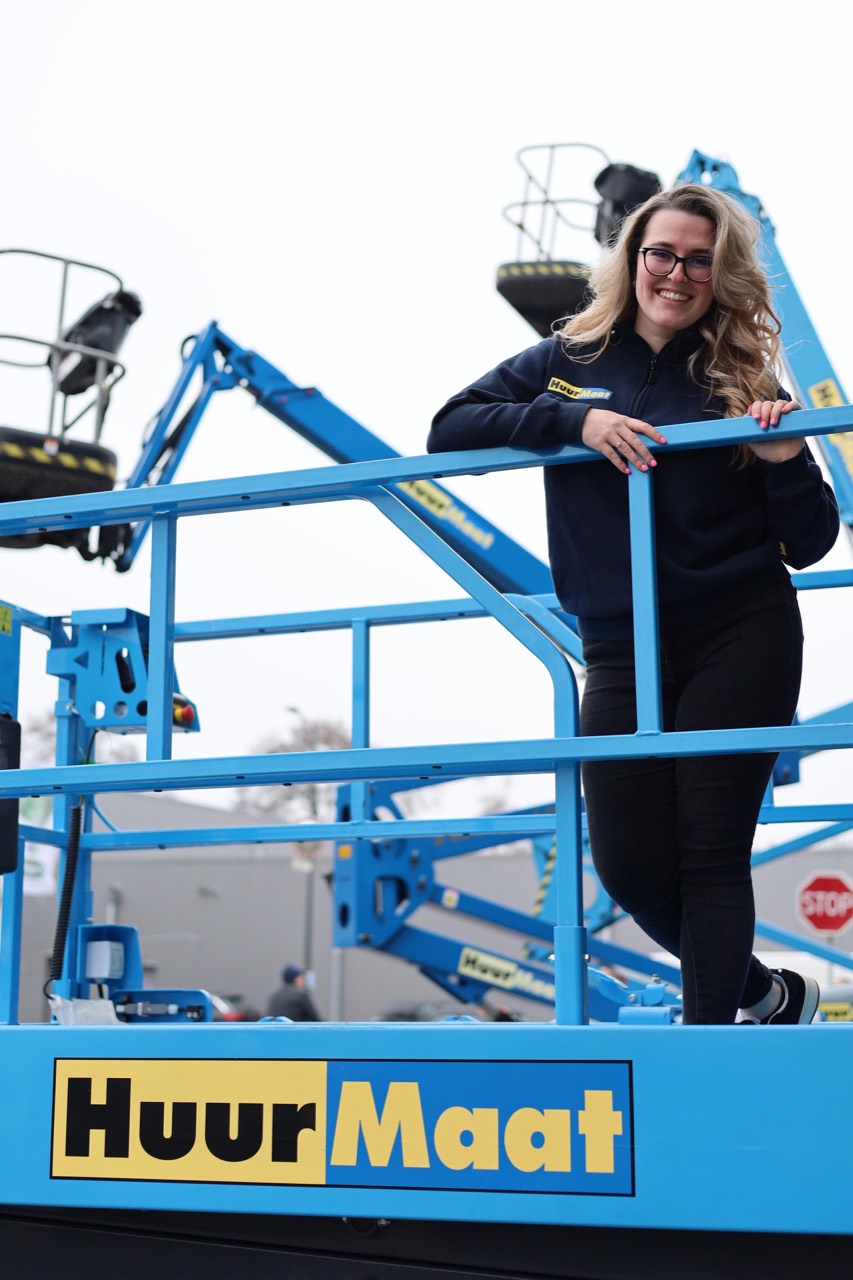 HuurMaat collega bij hoogwerker met logo
