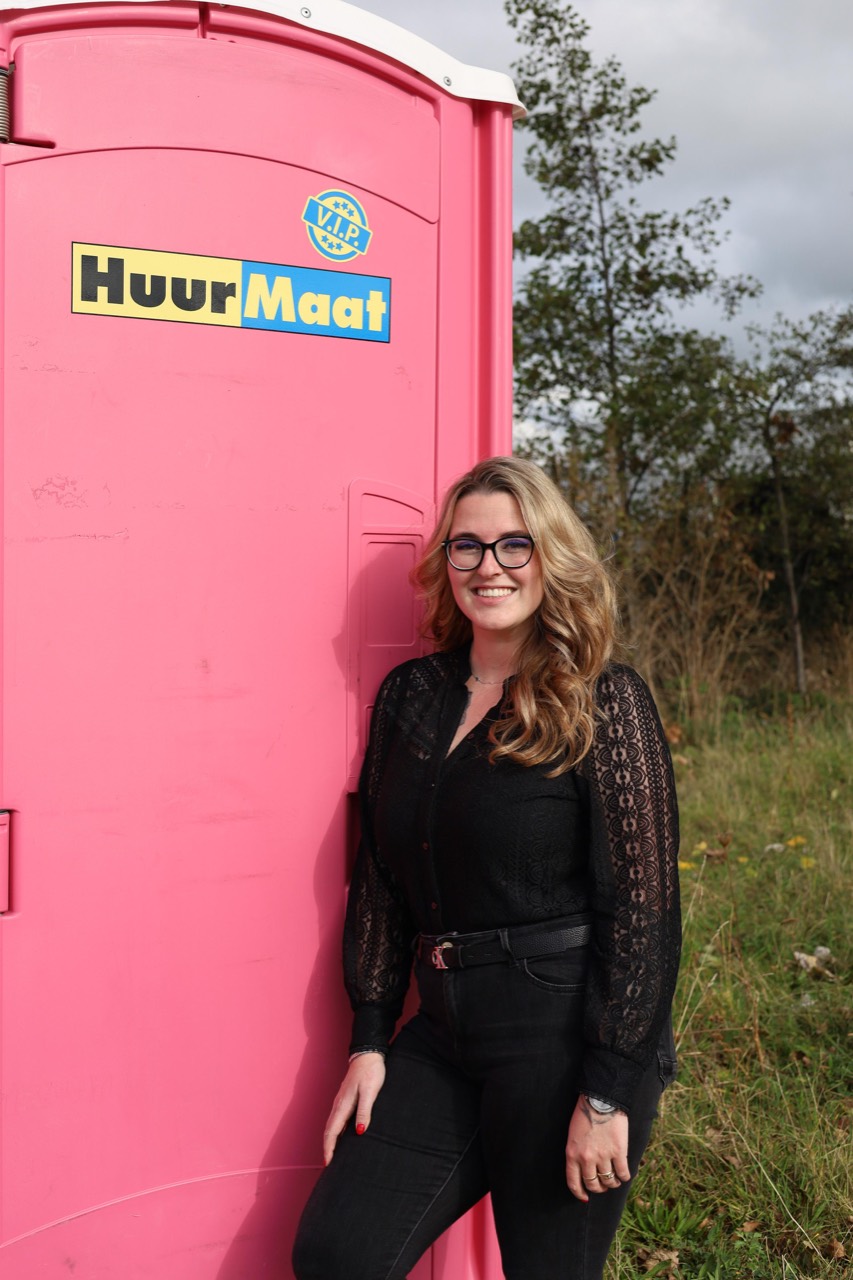 HuurMaat collega bij roze toiletunit